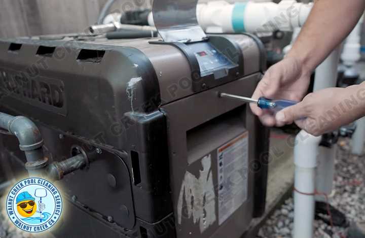 Technician repairing pool heating control system and equipment